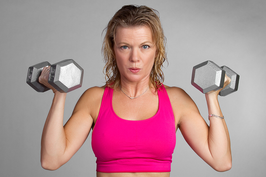 Woman demonstrating heavy lifting for women with dumbbell overhead press